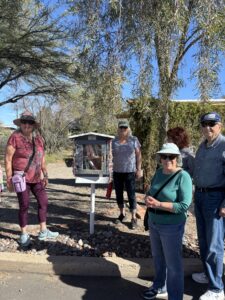 People gathered around outdoor little free library