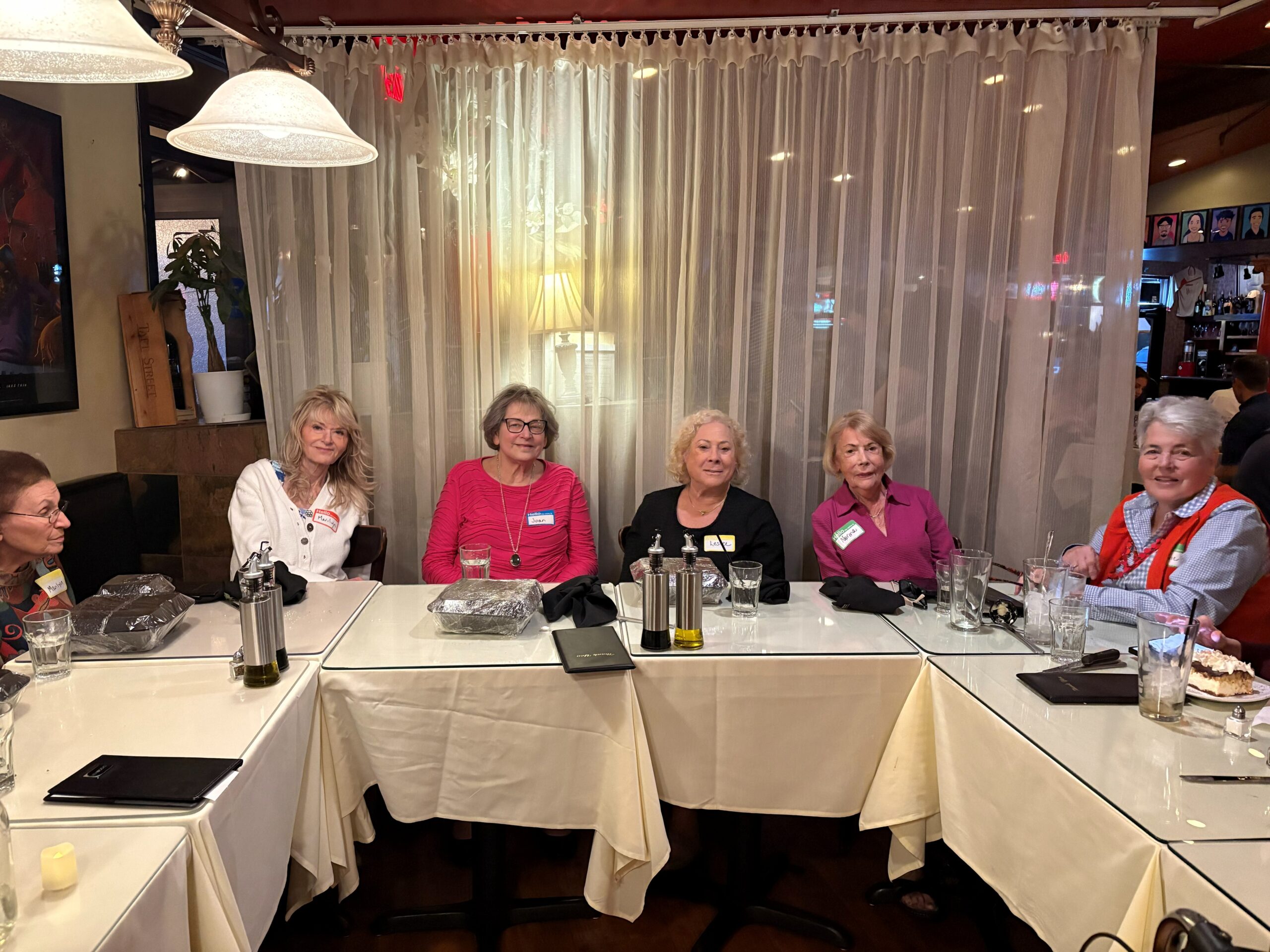 Women gathered around restaurant table smiling